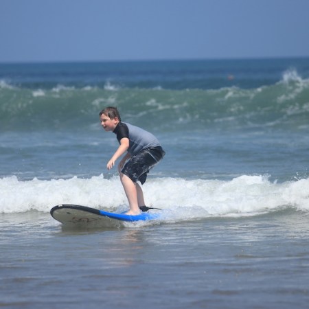 Boy learning to surf in Bali, Indonesia.