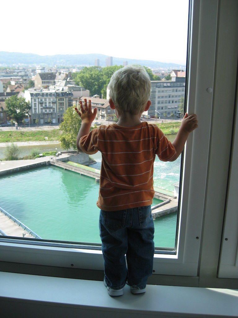 Boy looking out a hotel window in Europe.