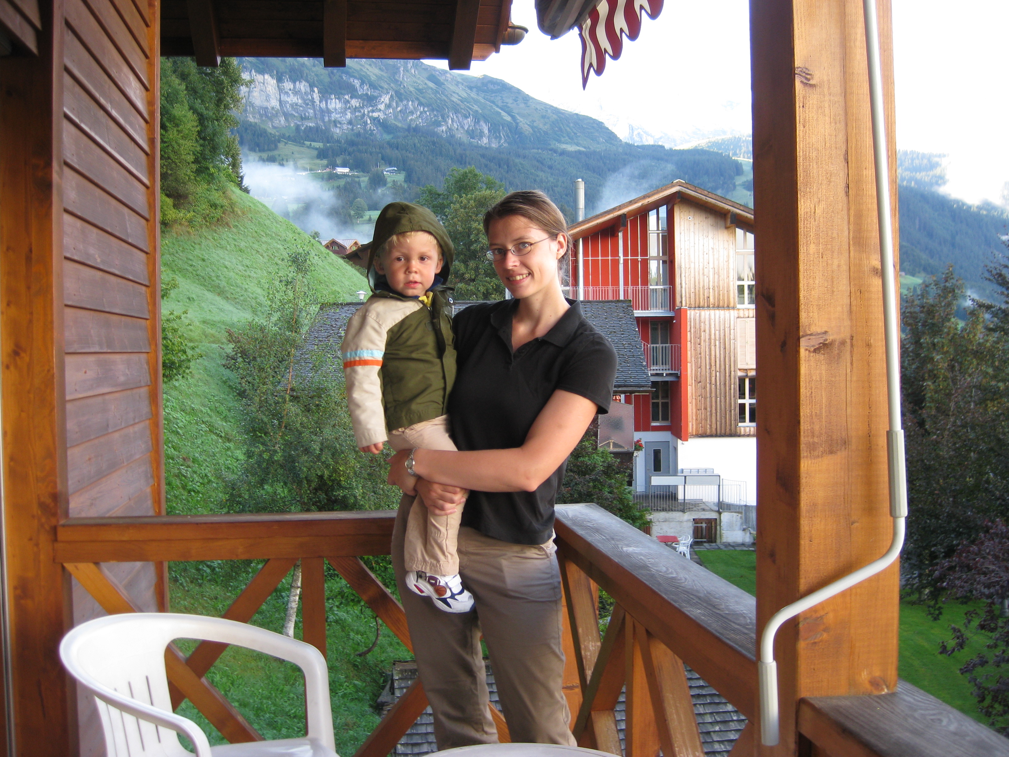 Mom and son on apartment balcony in Wengen, located in the Jungfrau Region of Switzerland.