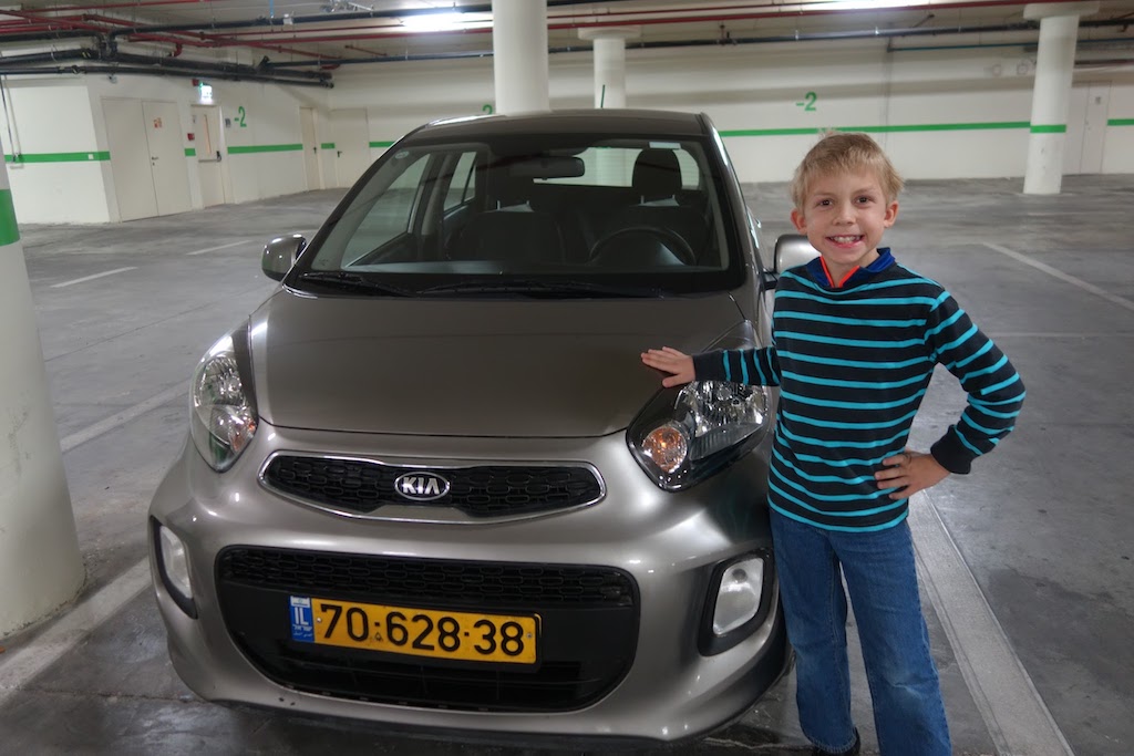 Boy by a rental car.