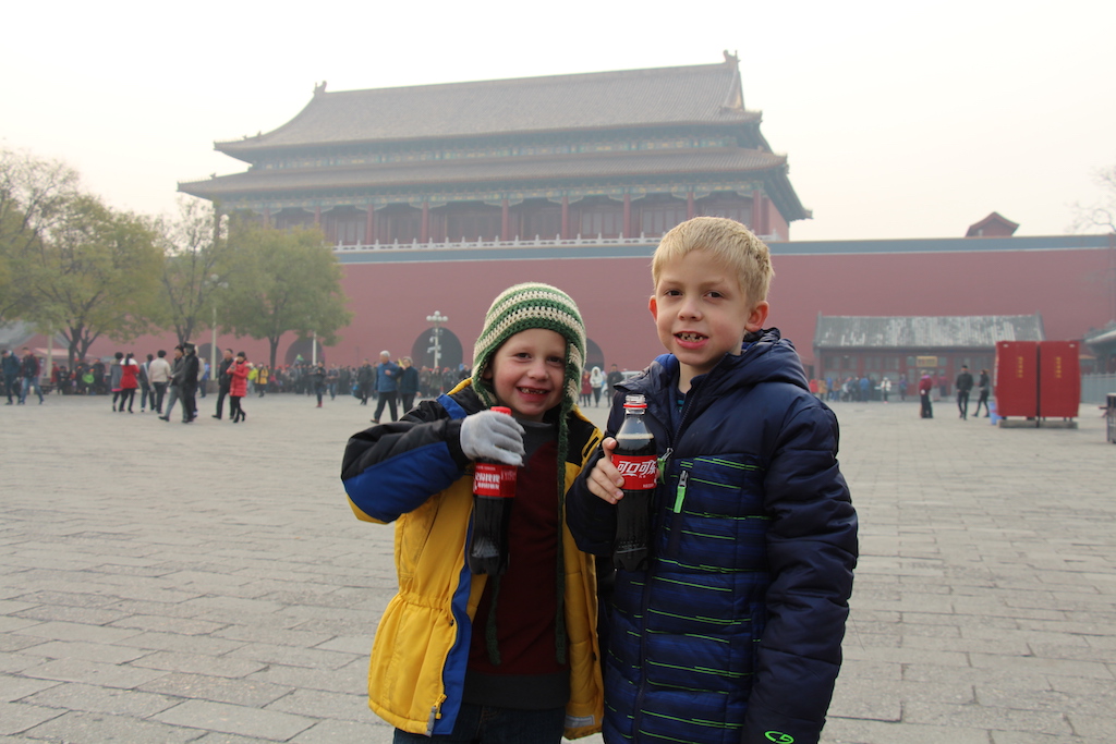 Two boys drinking coca cola at the Forbidden Palace in Beijing, China.