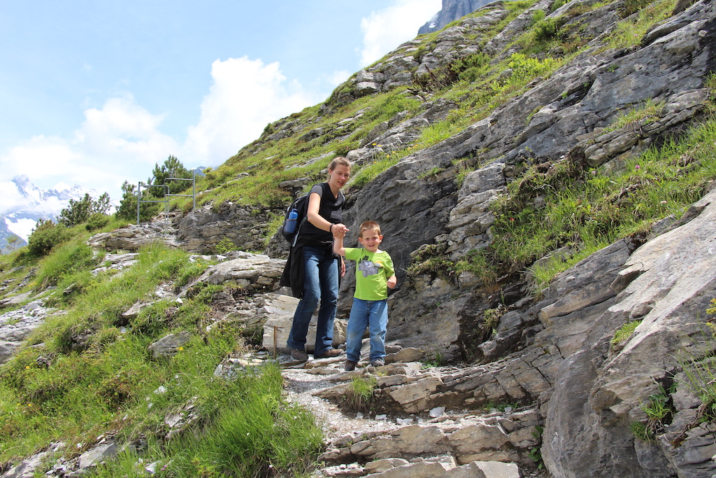 Mom and son hiking in the Jungfrau Region of the Swiss Alps in Switzerland.