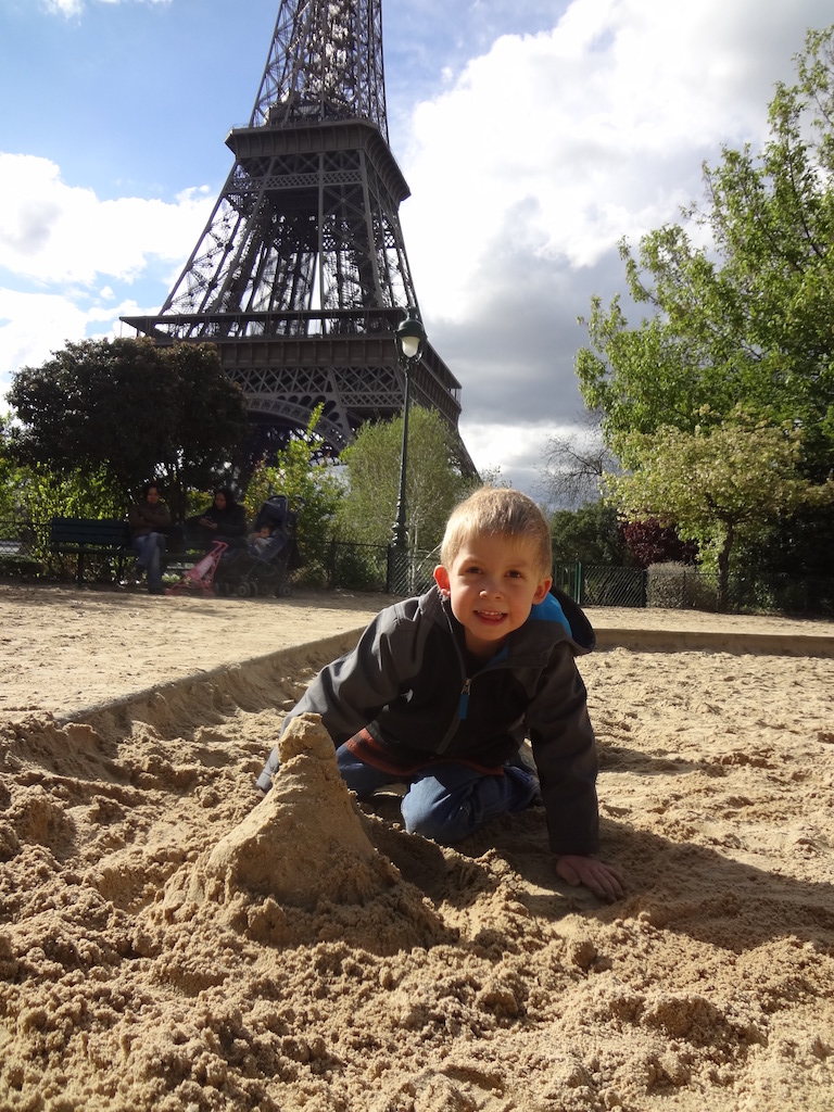 Building an Eiffel Tower sandcastle in front of the Eiffel Tower in Paris, France.