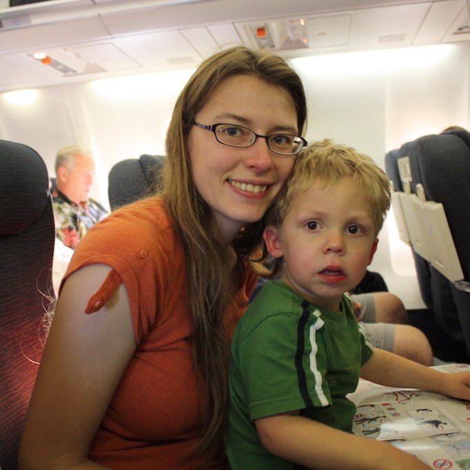 Boy reading the safety guide on an airplane.