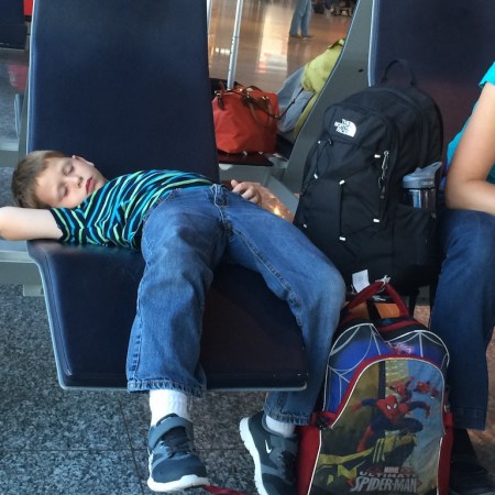 Boy sleeping in an airport.