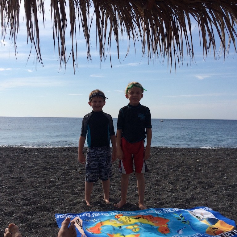 Playing on a pebbly beach on the island of Santorini in Greece.