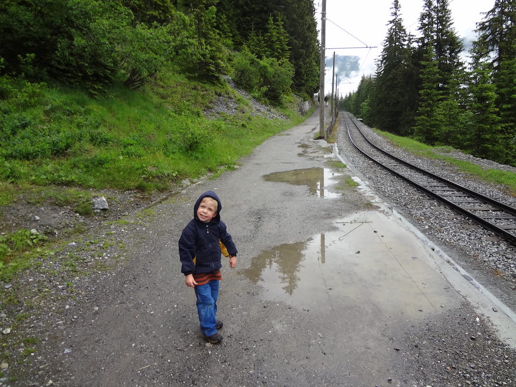Child hiking near some train tracks in the Jungfrau Region of Switzerland.
