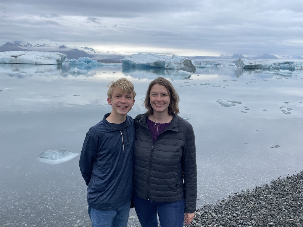 Mom and son standing by Jökulsárlón Glacier Lagoon in Iceland.